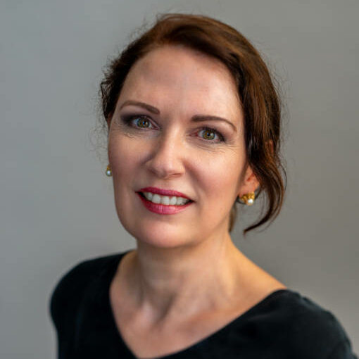 Portrait of an mature woman on a gray background. toothy smile.